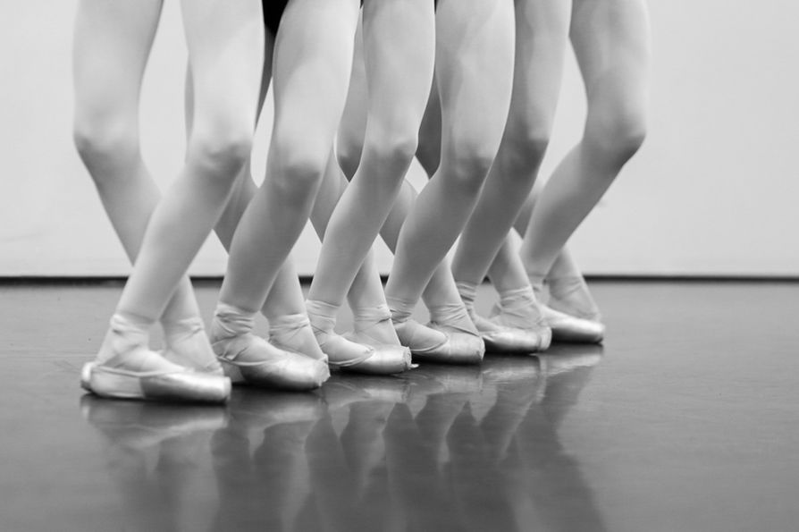 Row of ballet dancers' feet en pointe