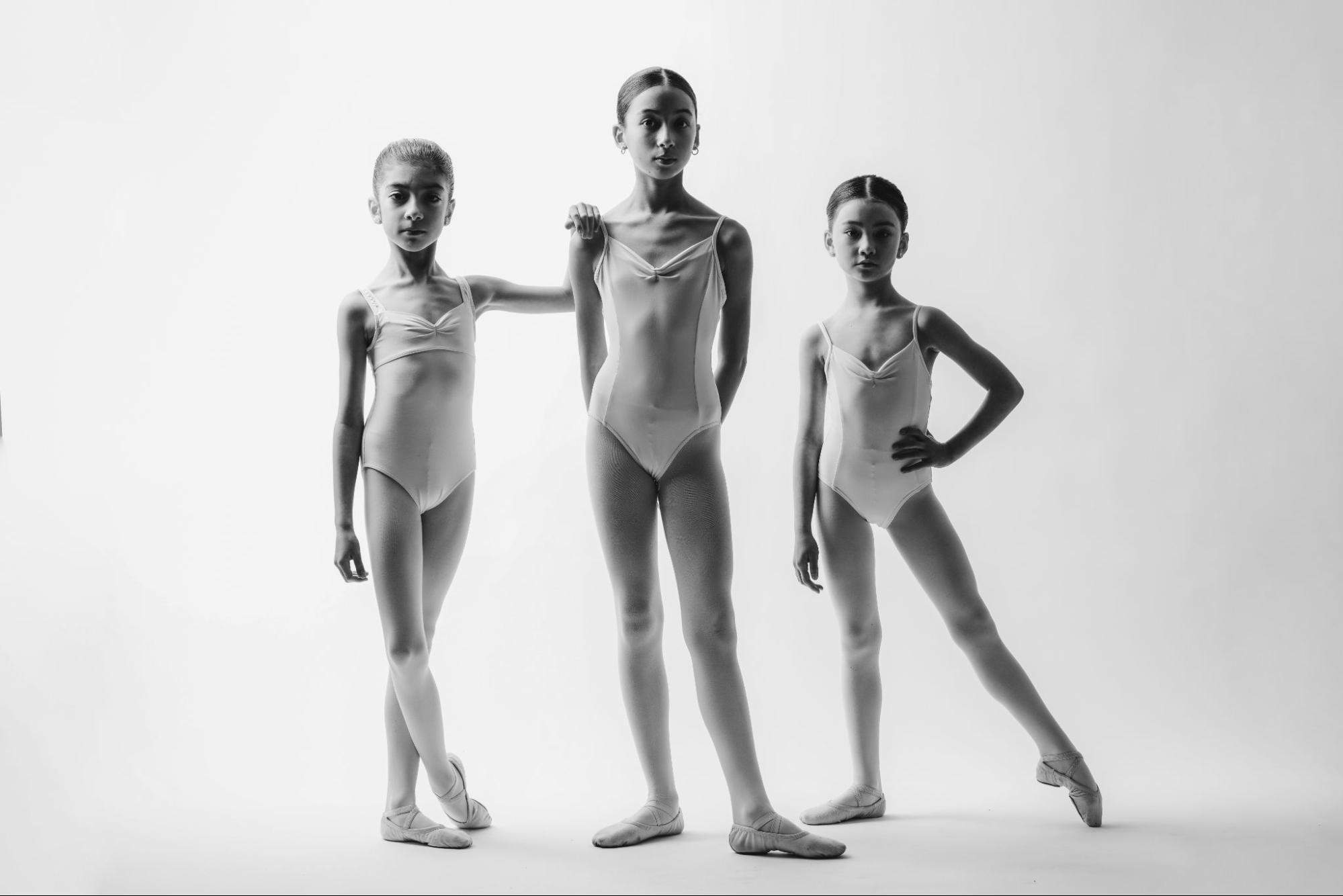 Three young ballet students posing in leotards